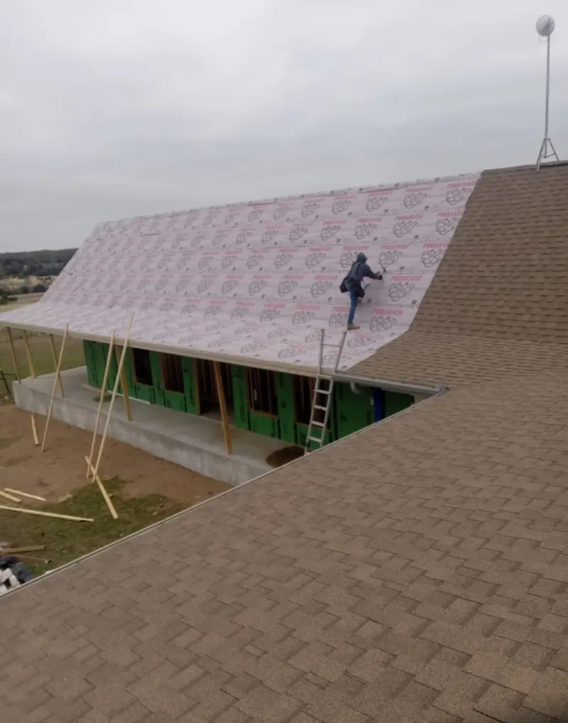 Worker preparing underlayment for a metal roof installation in Morehead City